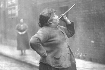 Mary Smith, dona despertador a l’East End de Londres, en plena feina amb la sarbatana. Fotografia de John Topham.