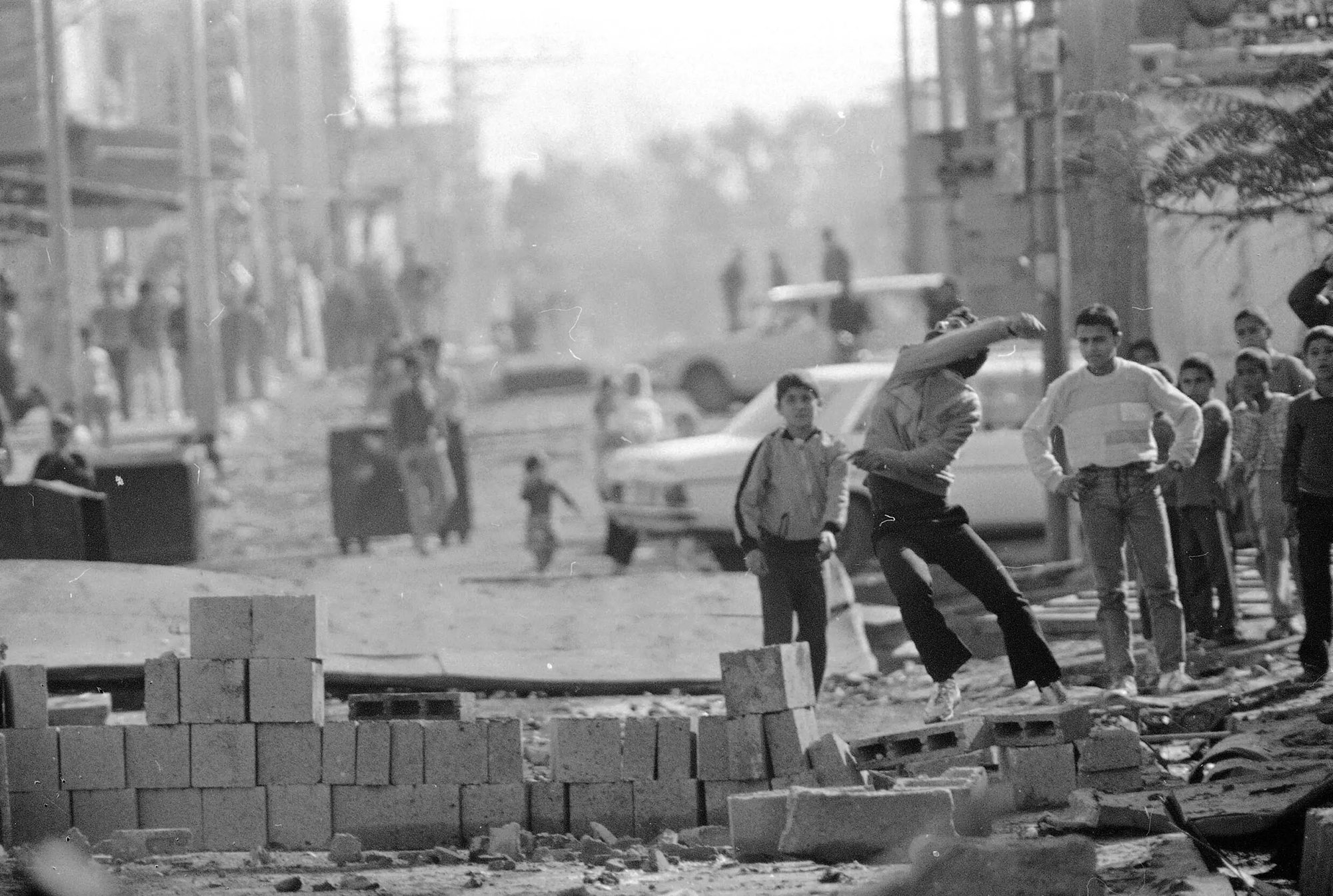 Un xaval llança pedres a l’exèrcit israelià a l’entrada al camp de refugiats de Bureij, a la franja de Gaza ocupada, 19.12.1987 (fotografia: Anat Givon/AP).