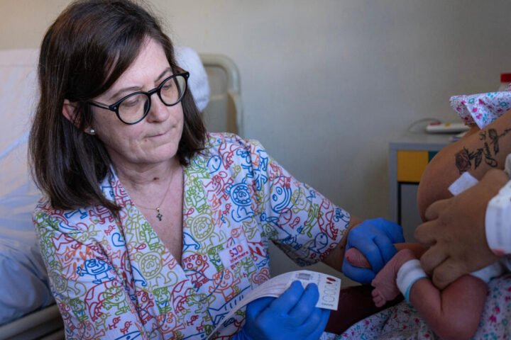 Una professional de l'Hospital Sant Joan de Déu fent la prova del taló a un nadó.