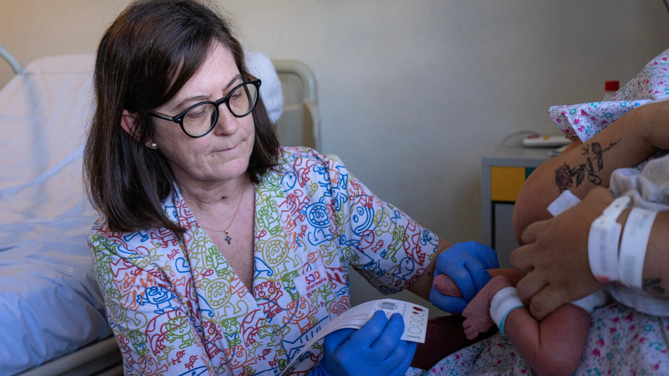 Una professional de l'Hospital Sant Joan de Déu fent la prova del taló a un nadó.