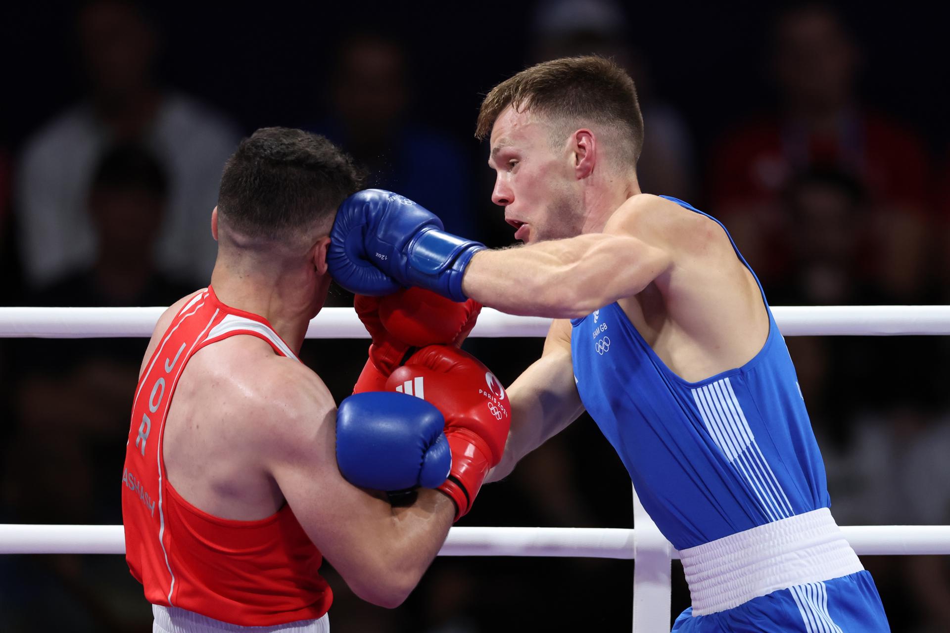 Lewis Richardson de Gran Bretanya (blau) i Zeyad Eashash de Jordània (vermell) en acció durant el seu combat