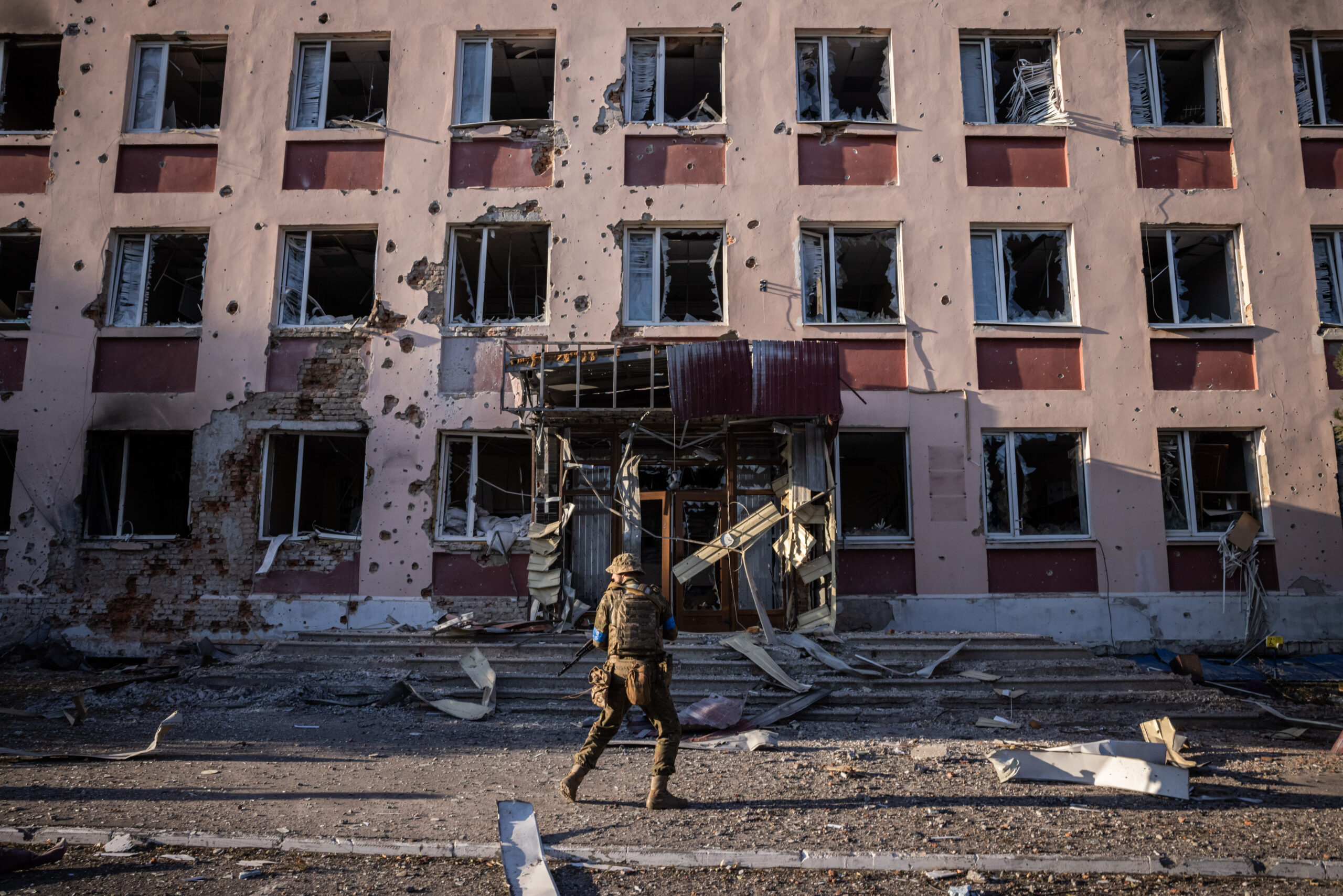 Un soldat ucraïnès passa pel costat d'un edifici amb l'impacte de metralla a la ciutat russa de Sudja, controlada per Ucraïna, dissabte passat (fotografia: Ed Ram/The Washington Post).