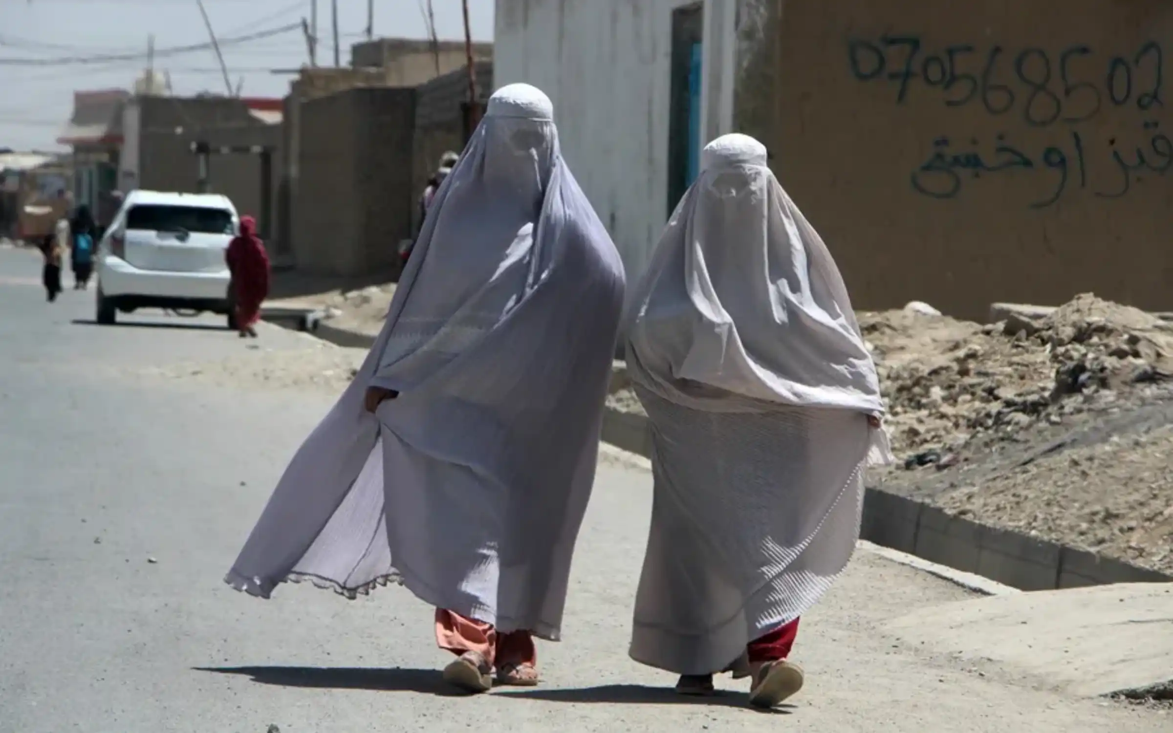 Dones amb burka caminen per una carretera de Kandahar, a l'Afganistan (fotgorafia: Qudratullah Razwan/EFE).