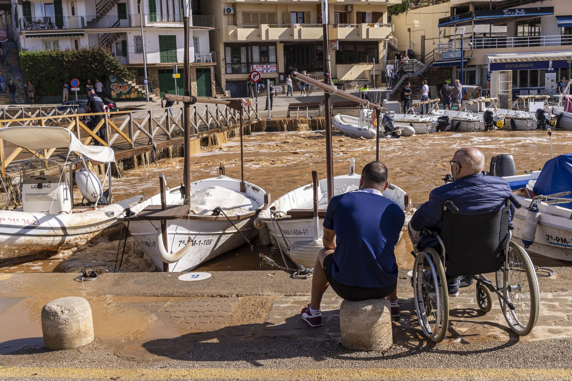 Dos homes mirant com ha quedat el torrent de Porto Cristo (fotografia: EFE / Cati Cladera).