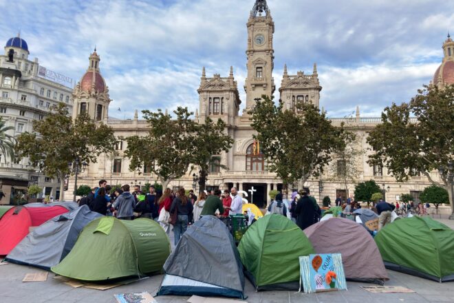 Un grup de persones passa la nit a la plaça de l’Ajuntament després d’una manifestació històrica a València