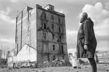 Enriqueta Marzal contemplant casa seva, un mes abans que l’enderroquessin. Vivia en aquest edifici del carrer del Puigmal, a l’avinguda Diagonal amb el carrer de Pere IV, afectat pel PERI del Parc Central. Febrer del 2003. Fotografia: Jordi Secall, cedida per Neret Edicions.