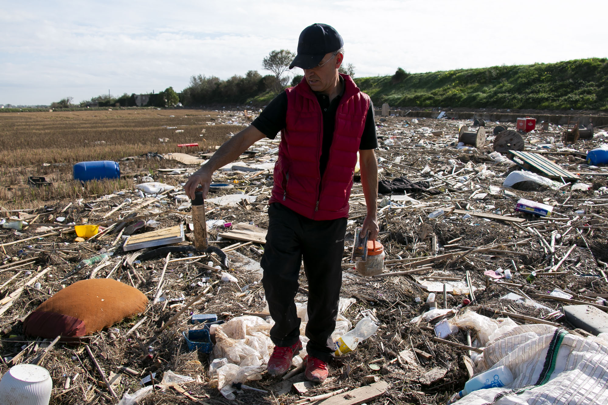 El llaurador Francesc Moncholí, ens mostra alguns dels productes cosmètics que ha trobat en el seu camp d'arròs, a Massanassa (fotografia: Laura Escartí)
