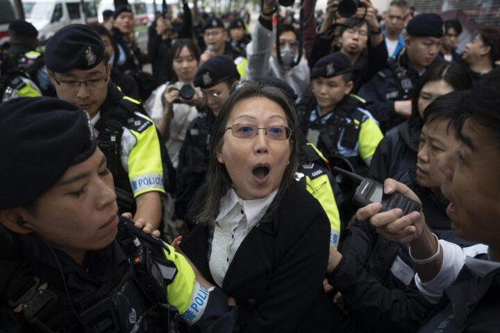 La policia reté una manifestant a la sortida del tribunal d'Hong Kong encarregat de dictar sentència sobre el cas dimarts (fotografia: Leung Man Hei/Efe).