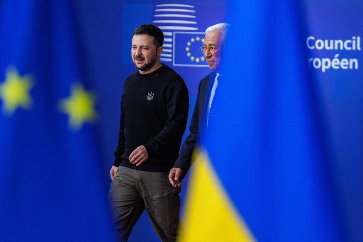 El president ucraïnès, Volodímir Zelenski (esquerra), i el president del Consell Europeu, António Costa (dreta), arriben dijous passat a la cimera de dirigents europeus a Brussel·les. En primer pla es veuen les banderes de la Unió Europea i d'Ucraïna (fotografia: Olivier Matthys/Efe).