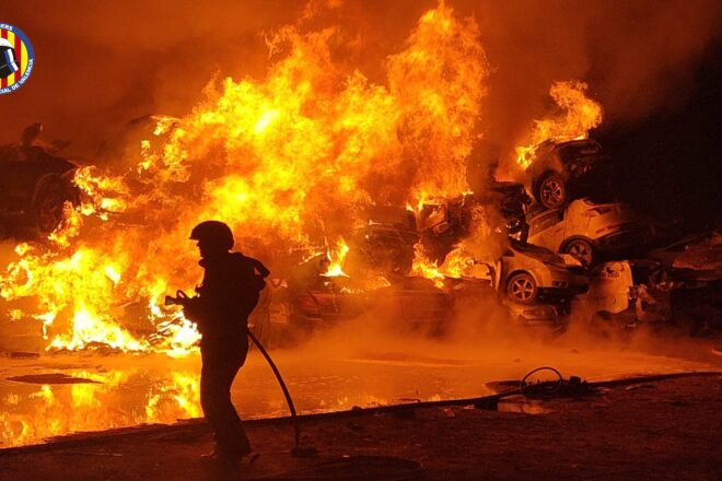 Els bombers apaguen el foc entre vehicles retirats per la gota freda en un solar de Catarroja