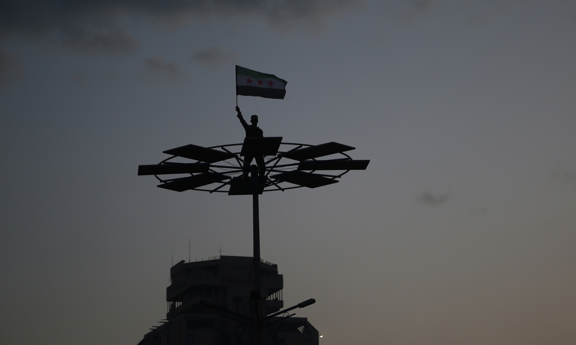 Pujat sobre un tanc, un soldat rebel celebra la caiguda del règim d'Assad a Síria, que va esfondrar-se per sorpresa després d'una ofensiva llampec de l'oposició aquest desembre (fotografia: Bilal Al Hammoud/Efe).