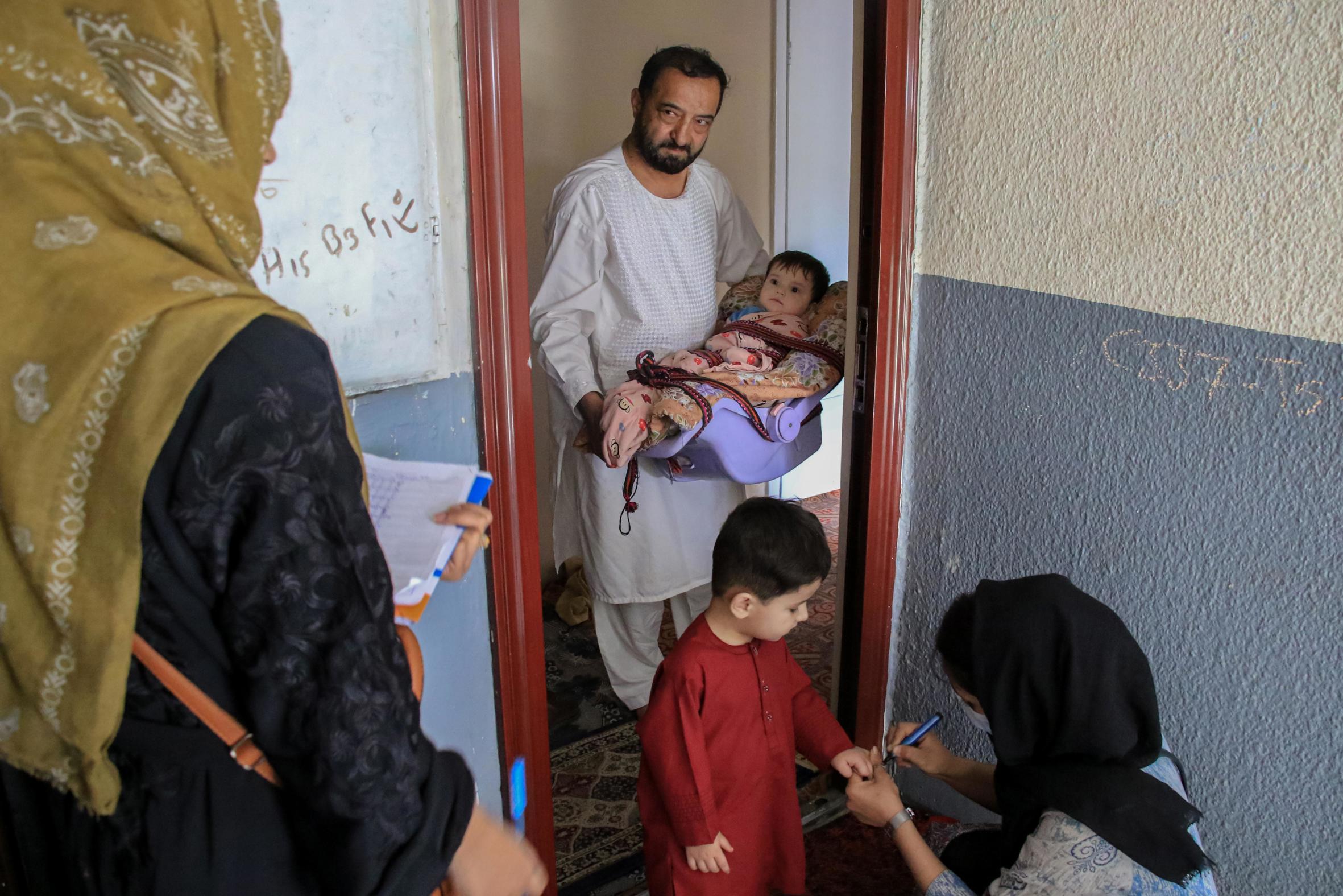 Dues treballadores sanitàries administren el vaccí de la pòlio a un infant a Kabul, la capital de l'Afganistan, la setmana passada. L'Afganistan és l'únic país del món on la pòlio continua essent endèmica, i el virus sovint sol passar la frontera cap a l'oest del Paquistan (fotografia: Samiullah Popal/Efe).