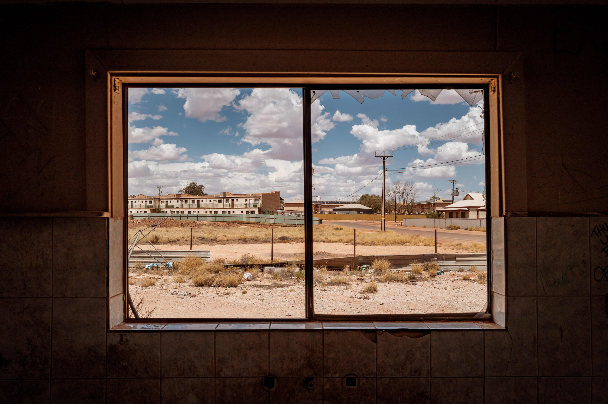Vista a través de la finestra trencada d'una casa abandonada al poble de Coober Pedy, a l'interior de l'estat australià d'Austràlia Meridional (fotografia: Tamati Smith/The Washington Post).