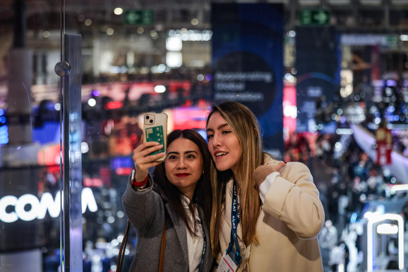 Dues assistents al MWC 2025 es fan una fotografia.