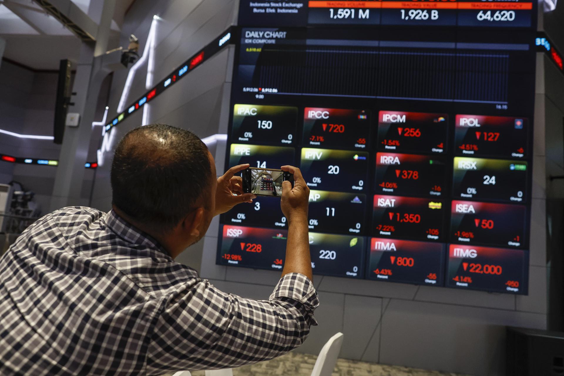 Una persona fotografia la caiguda a la borsa de Jakarta. (Fotografia de Mast Irham)