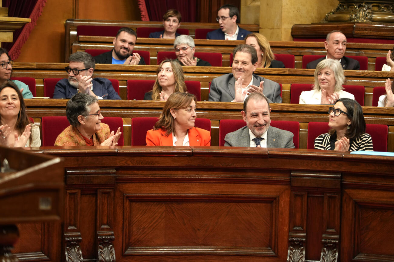 La consellera Sílvia Paneque somriu mentre els consellers l'aplaudeixen una volta que el parlament hagi validat la regulació del lloguer de temporada.