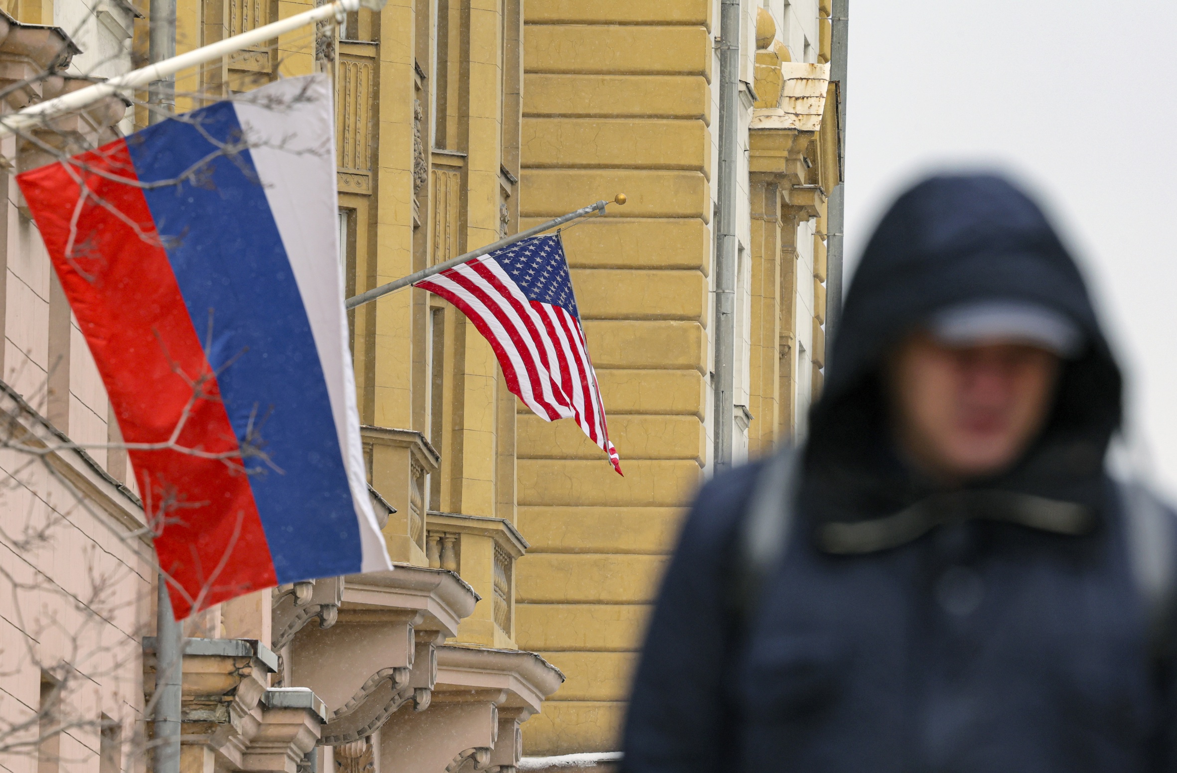 Un home passa per davant d'una façana on pengen les banderes de Rússia i els Estats Units ahir a Moscou, durant la segona ronda de consultes diplomàtiques entre Washington i Moscou per a posar fi a la guerra d'Ucraïna (fotografia: Maxim Shipenkov/Efe).