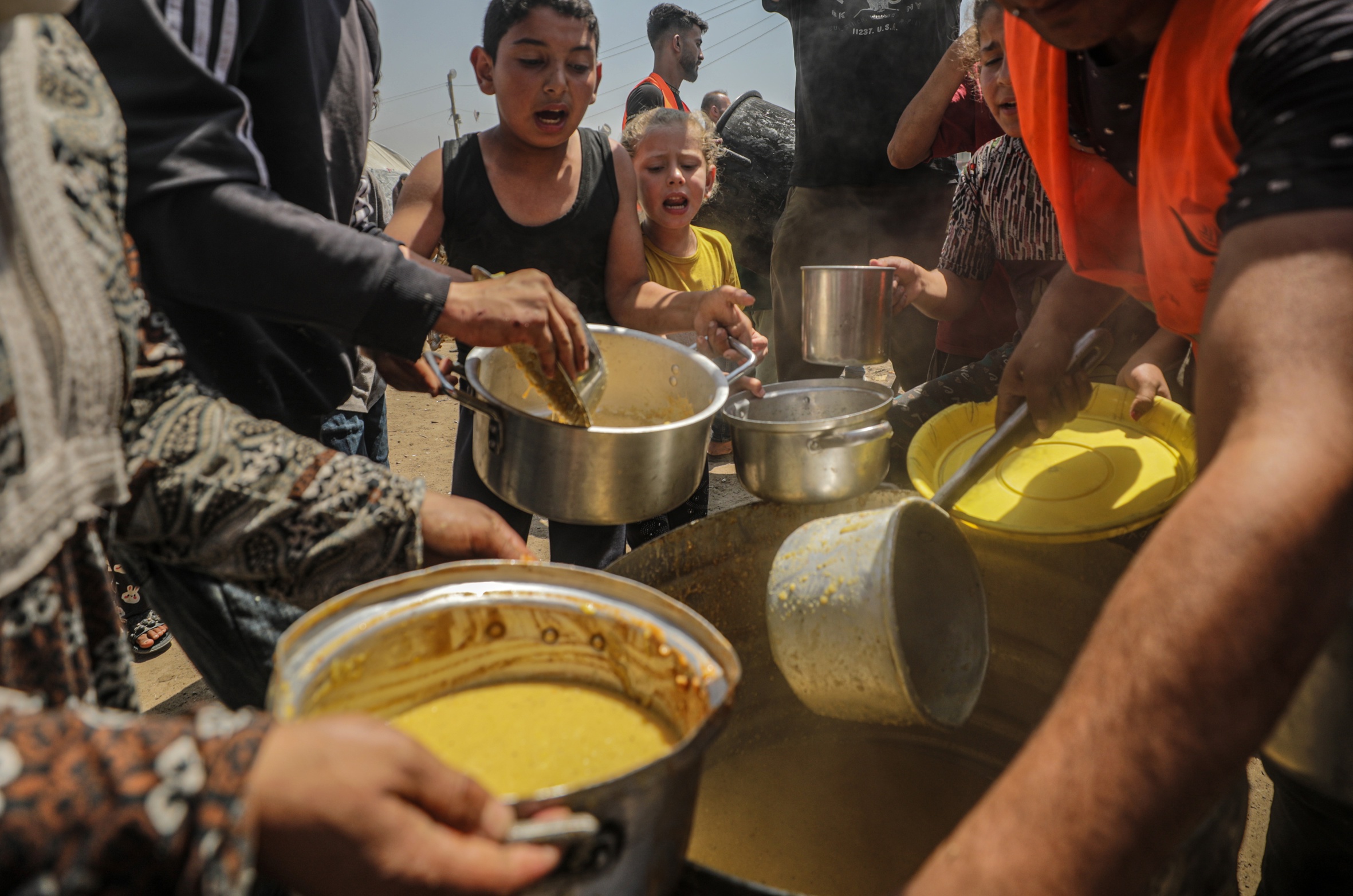 Refugiats interns palestins fan cua per a rebre menjar al camp de refugiats de Jabalia, al nord de Gaza (fotografia: Mohammed Saber/Efe).