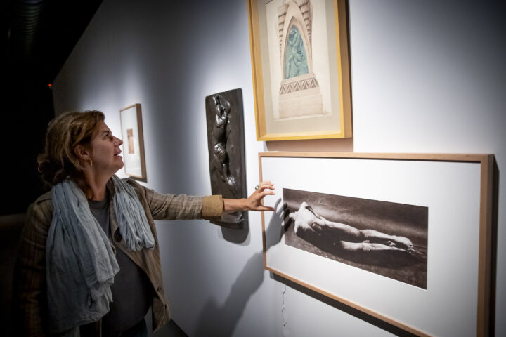 La galerista Mònica Ramon mira una de les fotografies de Toni Catany de la sèrie ‘Somniar déus’.