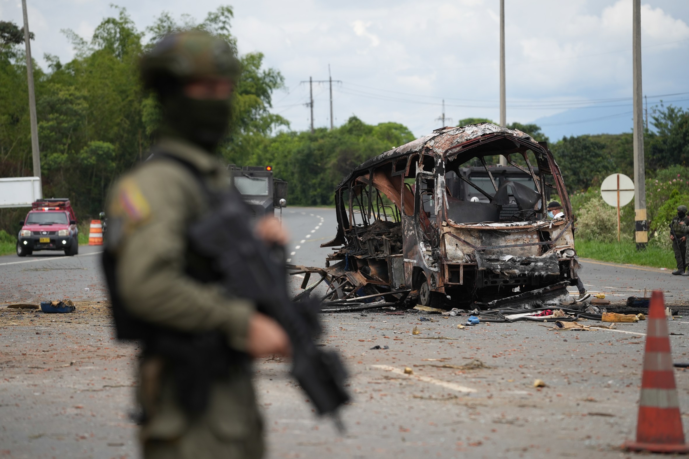 Restes d'un autobús objecte d'un atac amb bomba a Villa Rica, Colòmbia, dimarts de la setmana passada, amb un militar en primer pla (fotografia: Ernesto Guzmán/Efe).