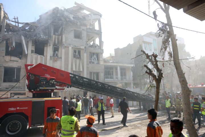 Un grup de bombers rescaten residents d'un edifici residencial de Teheran destruït en l'atac israelià d'ahir (fotografia: Abedin Taherkenareh/Efe).