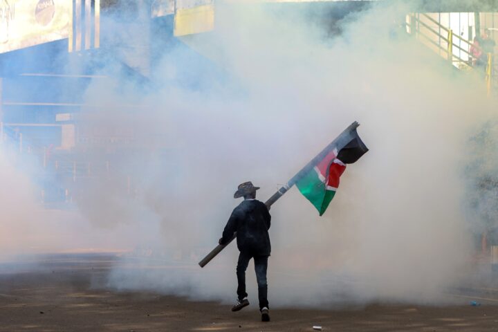 Un manifestant oneja una bandera de Kènia mentre prova d'evitar el gas lacrimogen durant una manifestació a la capital del país, Nairobi, la setmana passada (fotografia: Str/Efe).