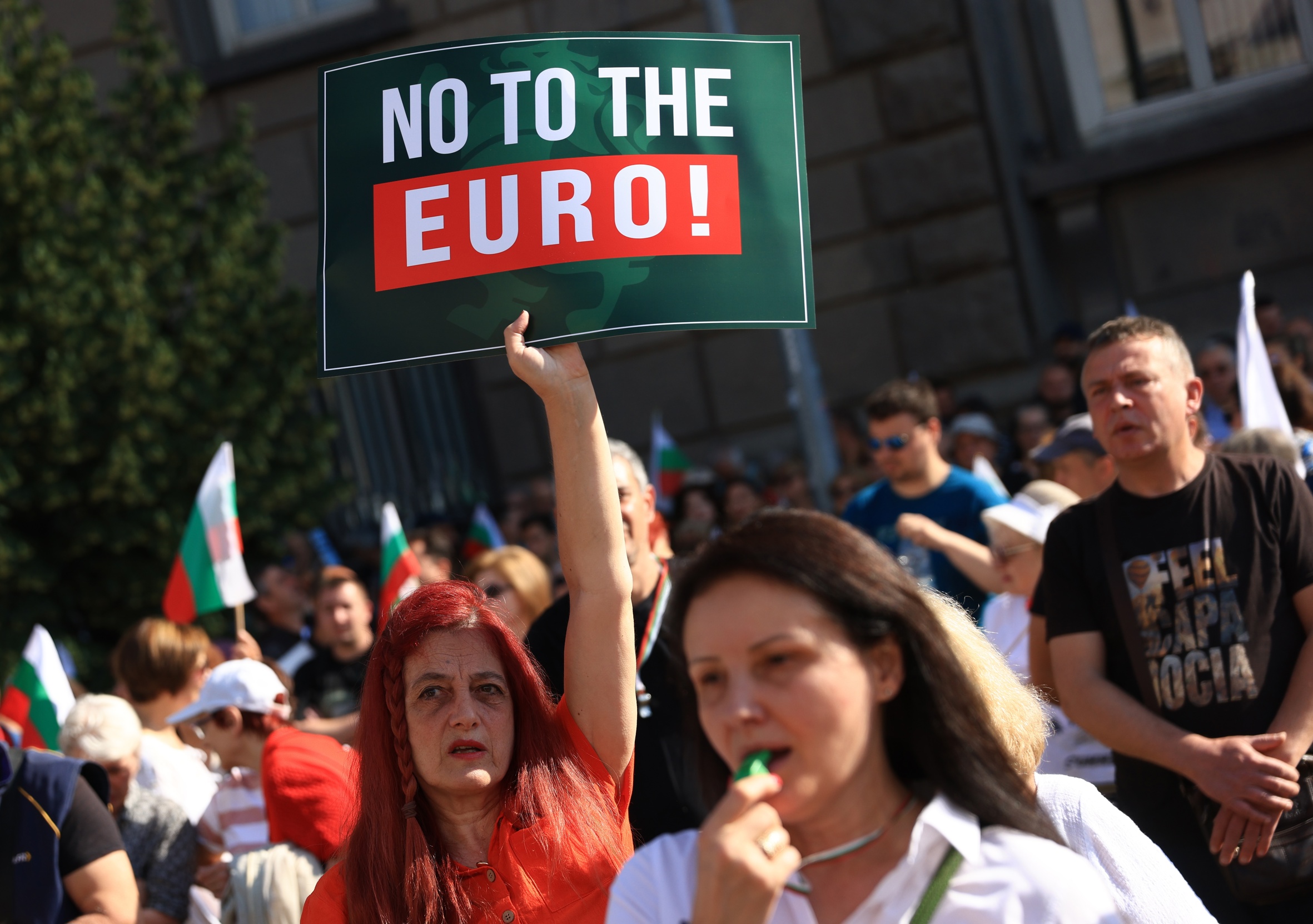 Una dona sosté un cartell en què es llegeix, en anglès, 