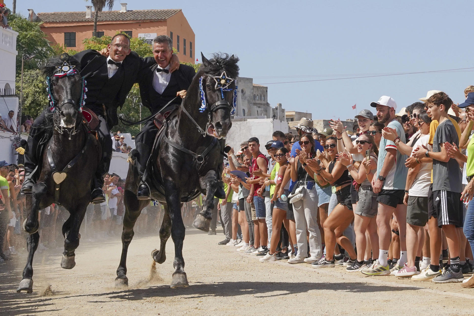 Dos cavallers corren abraçats en els jocs del matí (fotografia: EFE / David Arquimbau)