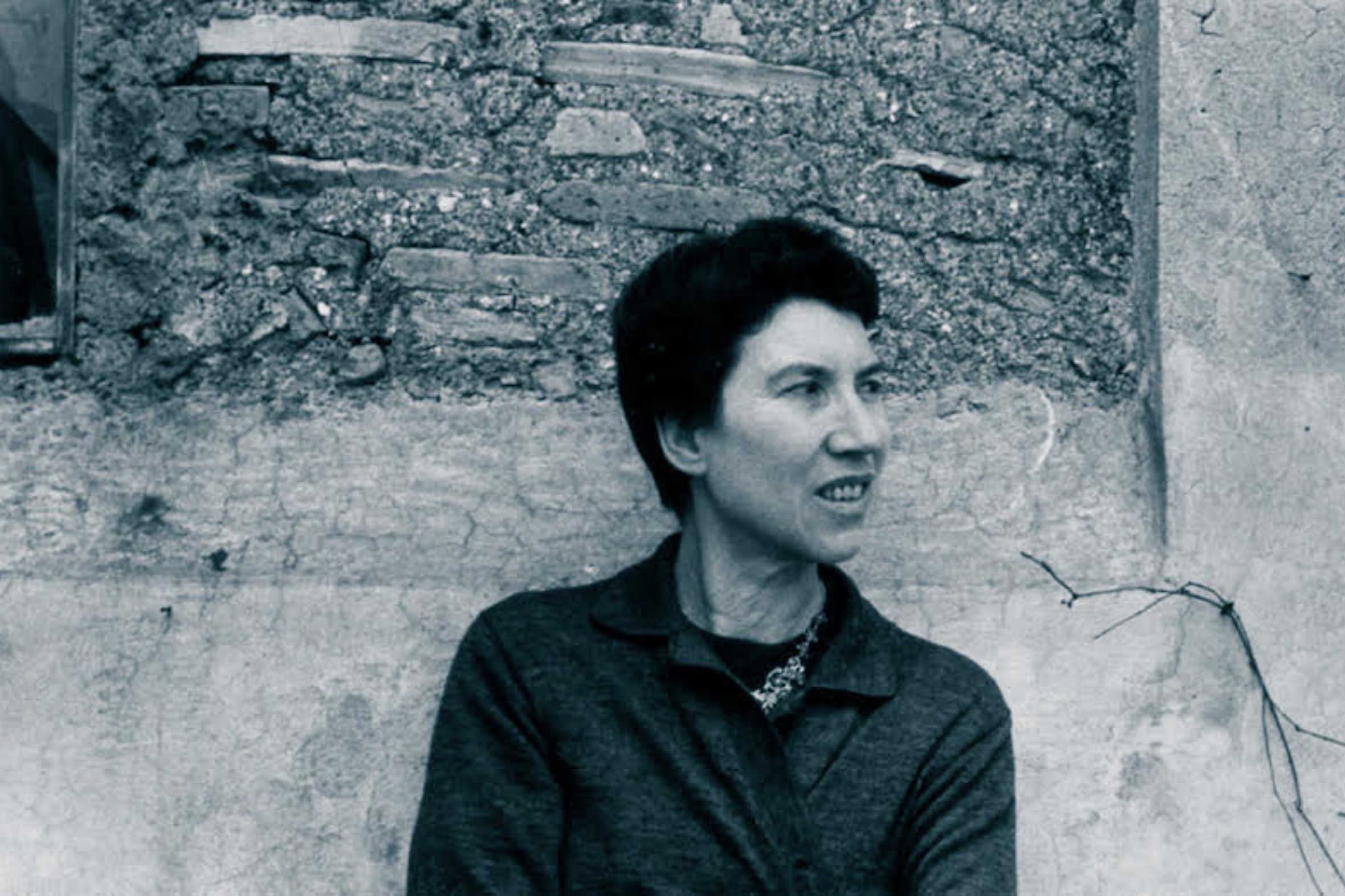 L’escriptora italiana Natalia Ginzburg amagant la llufa contra el mur.