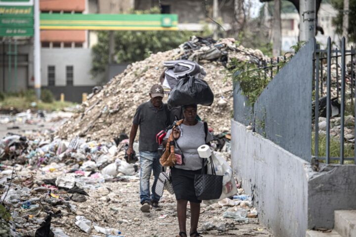 Refugiats caminen entre la runa en un carrer de la vora del Palau Nacional d'Haití, a Port-au-Prince, a final de juny (fotografia: Mentor David Lorens/Efe).