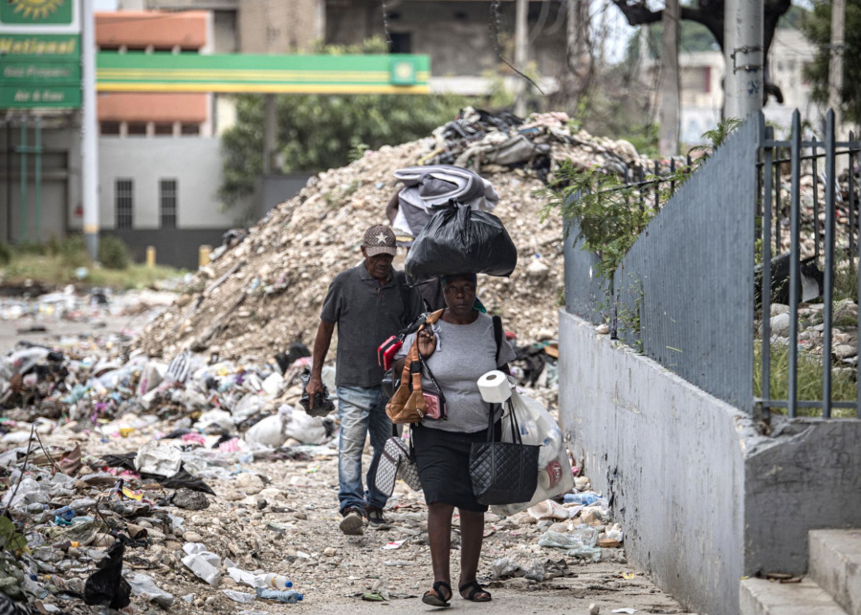 Refugiats caminen entre la runa en un carrer de la vora del Palau Nacional d'Haití, a Port-au-Prince, a final de juny (fotografia: Mentor David Lorens/Efe).