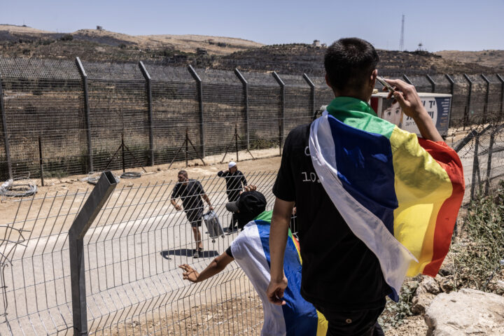 Dos joves amb banderes druses en la línia de demarcació entre Israel i Síria (Fotografia: Heidi Levine/The Washington Post)