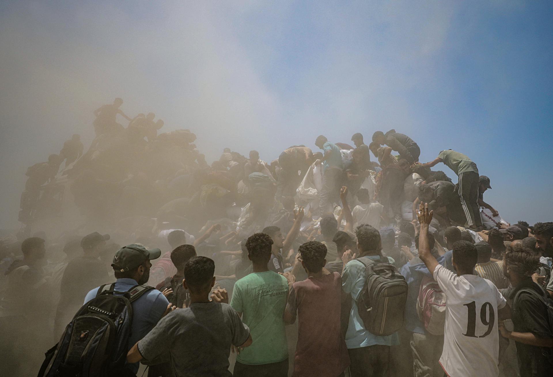 Un grup de palestins desplaçats interns intenta d’aconseguir bosses de farina d’un camió d’ajuda prop d’un punt de distribució d’aliments a Zikim, al nord de Gaza, enmig d’una situació desesperada per la manca de subministraments bàsics (fotografia: Mohammed Saber).