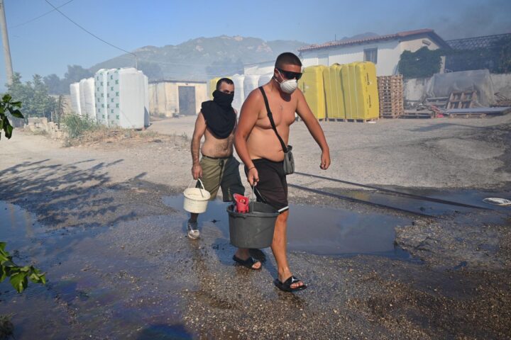 Residents de Platani, al Peloponès, intenten ajudar a apagar el foc. (Fotografia:Giota Lotsari)