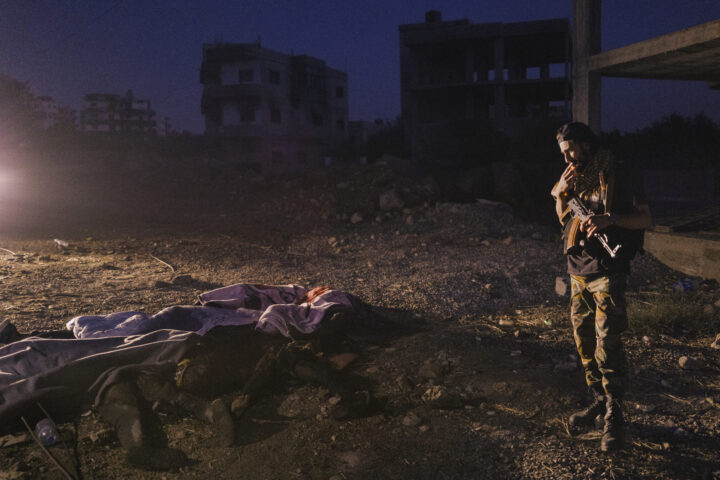 Un militant drus mira una pila de cadàvers cremats, coberts parcialment amb mantes, a As-Suwayda, el proppassat 24 de juliol (fotografia: Lorenzo Tugnoli/The Washington Post).