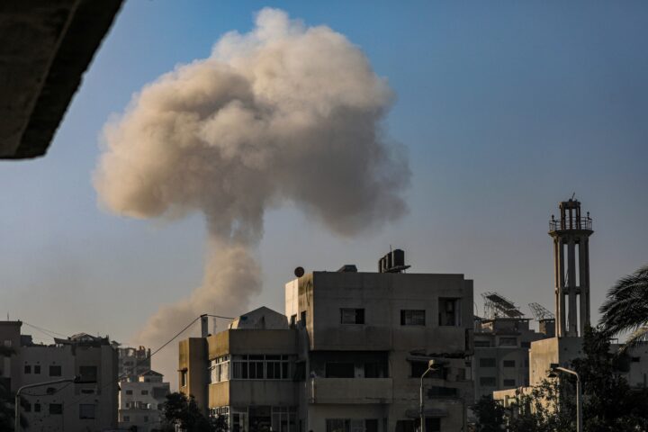 Una columna de fum causada per un atac aeri israelià s'alça rere un edifici del barri d'Al Sabra, a la ciutat de Gaza, abans-d'ahir (fotografia: Mohammed Saber/Efe).