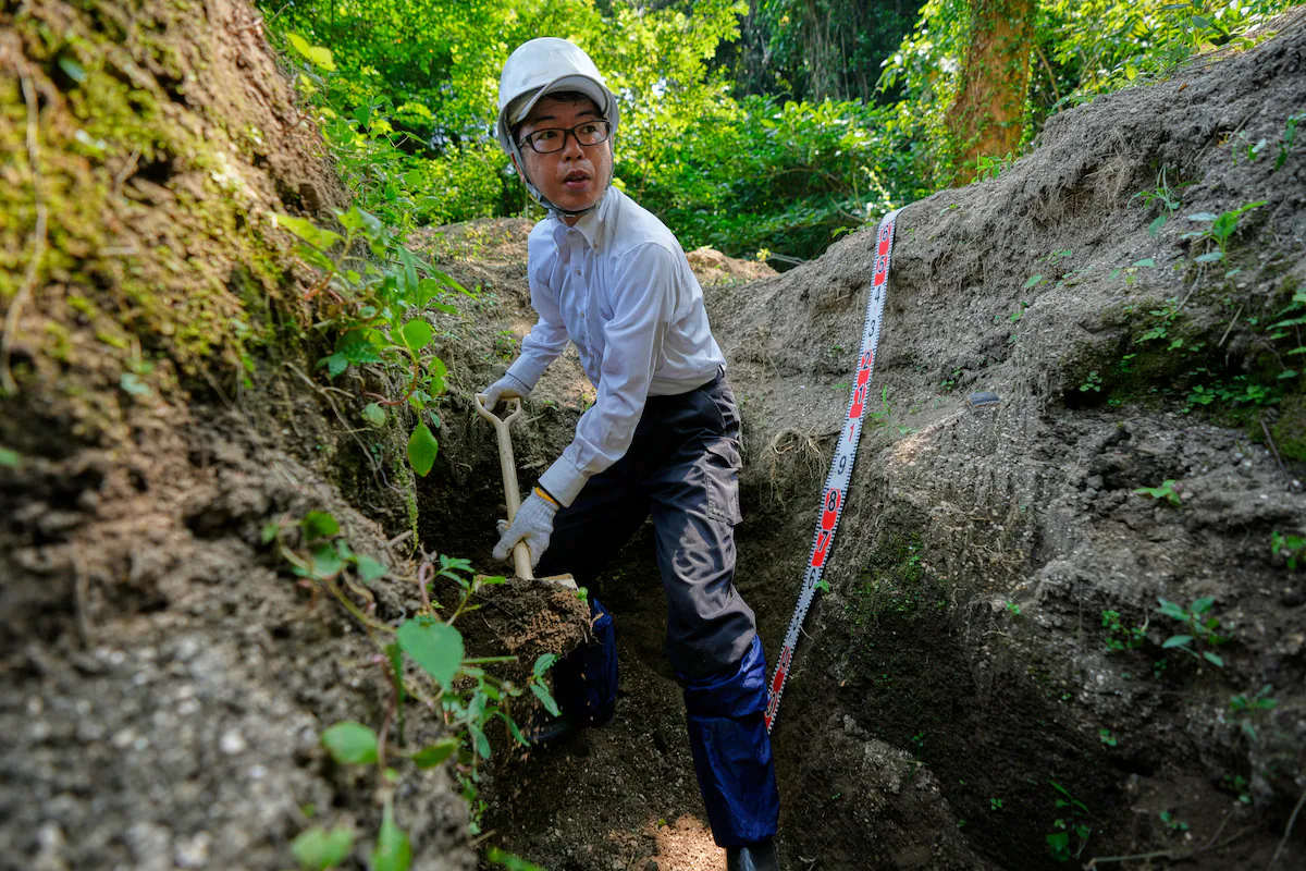 Rebun Kayo, investigador de la Universitat d'Hiroshima, cerca restes de víctimes del bombardament d'Hiroshima a l'illa de Ninoshima, aquest juliol (fotografia: Eugene Hoshiko/The Associated Press).