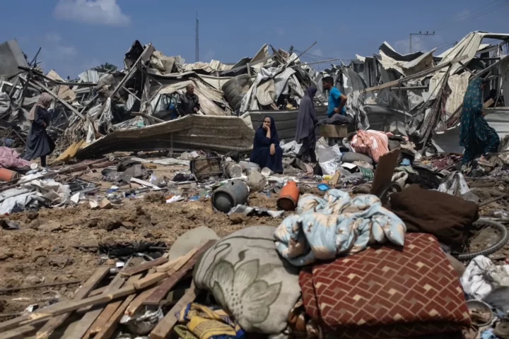 Refugiats palestins inspeccionen les restes d'una tenda destruïda per un atac israelià contra el campament de refugiats d'al-Manasrah, a Gaza (fotografia: Haitham Imad/Efe).