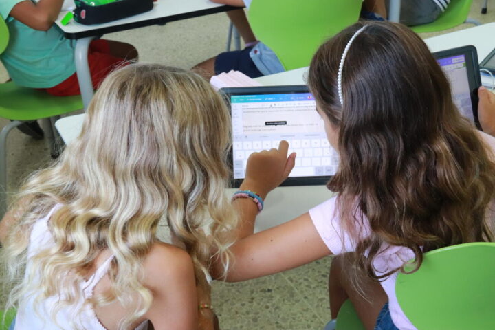 Imatge d'arxiu d'unes alumnes de primària treballant a l’aula amb una tauleta.