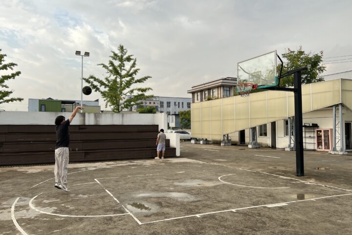 Dos residents de la comuna d'Anji juguen un partit de bàsquet als afores del complex (fotografia: Christian Shepherd/The Washington Post).