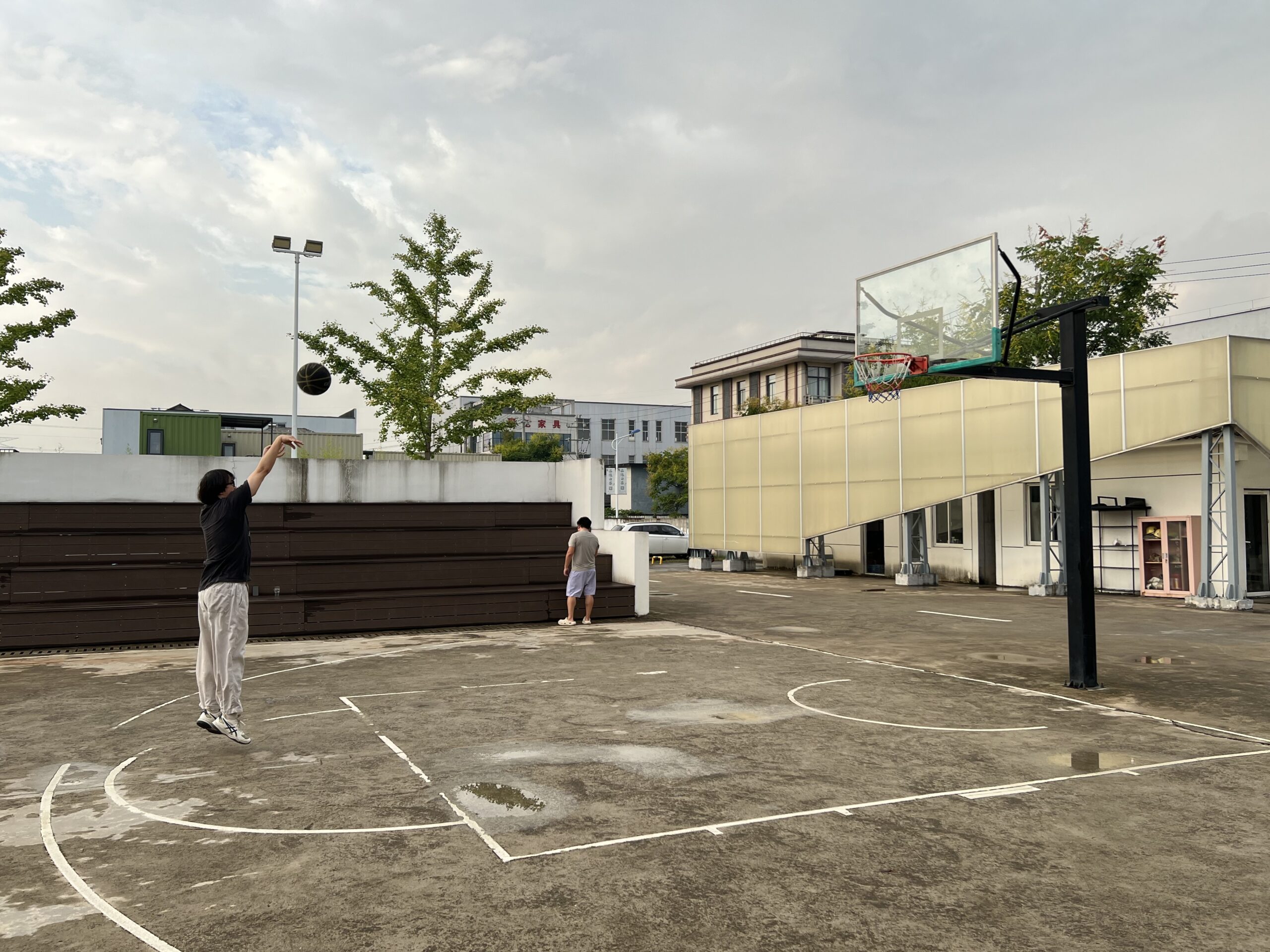 Dos residents de la comuna d'Anji juguen un partit de bàsquet als afores del complex (fotografia: Christian Shepherd/The Washington Post).