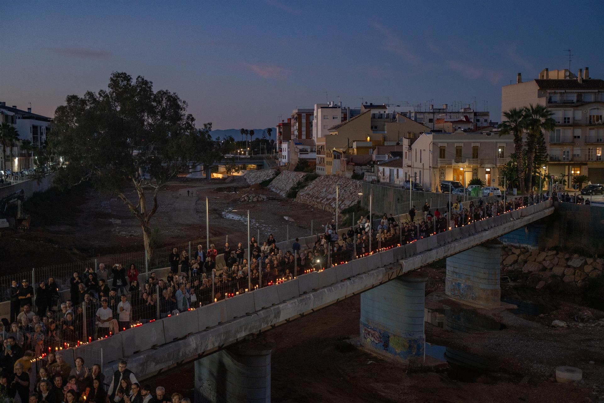 Desenes de persones encenen espelmes a la rambla de Torrent per mantenir viva la memòria de les víctimes de la gota freda.