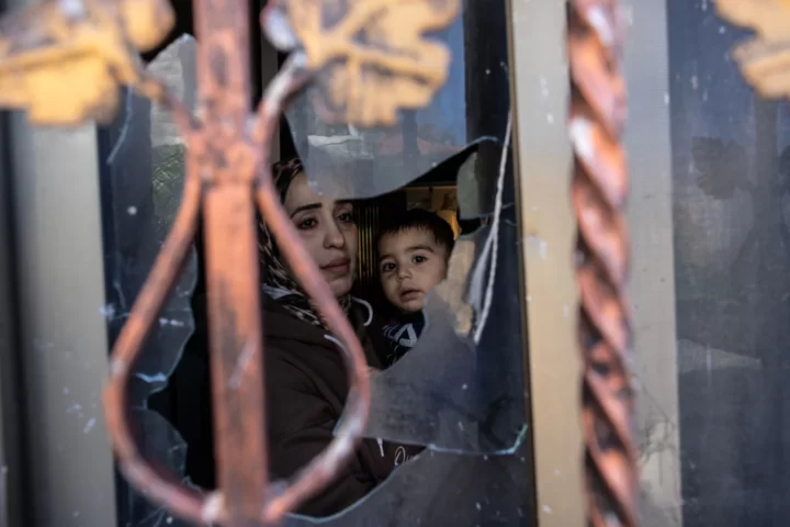 Wafa Abu Subhieh agafa als braços el seu fill Rezik, de catorze mesos, rere una de les finestres de casa seva, esbotzada per assaltants jueus a Jaba, dimarts. Subhieh era a casa amb els seus tres fills en el moment de l'atac (fotografia: (Heidi Levine/The Washington Post).