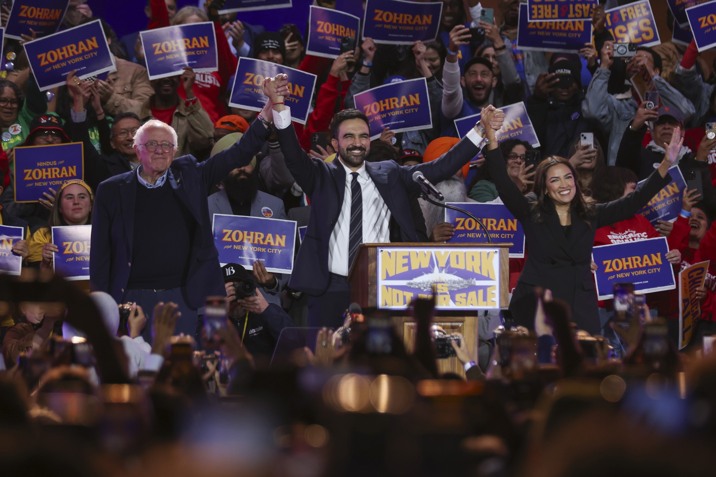 Mamdani (centre) saluda els seus seguidors durant un acte polític amb el senador Bernie Sanders (esquerra) i la representant Alexandria Ocasio-Cortez (dreta) a Nova York, la setmana passada (fotografia: Sarah Yenesel/Efe).