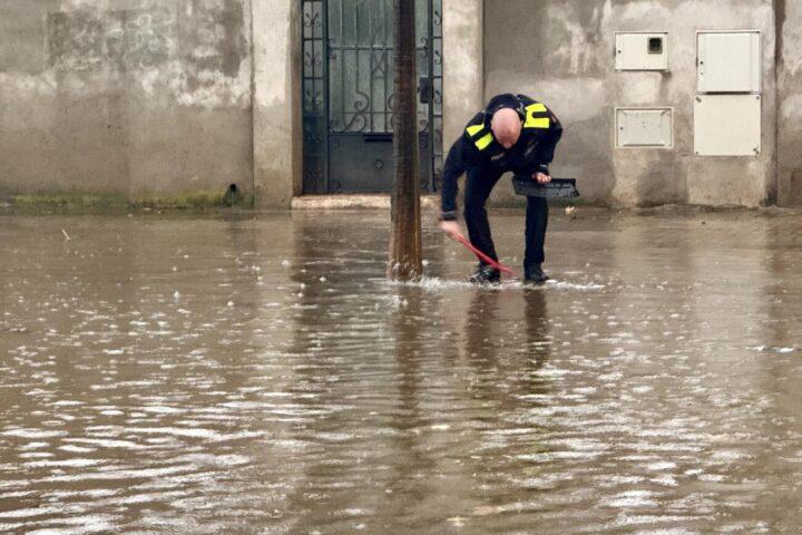 Un agent de la Plicia Municipal de Sabadell mira de destapar les entrades de les clavegueres a la rambla d'Ibèria. Fotografia: ACN.