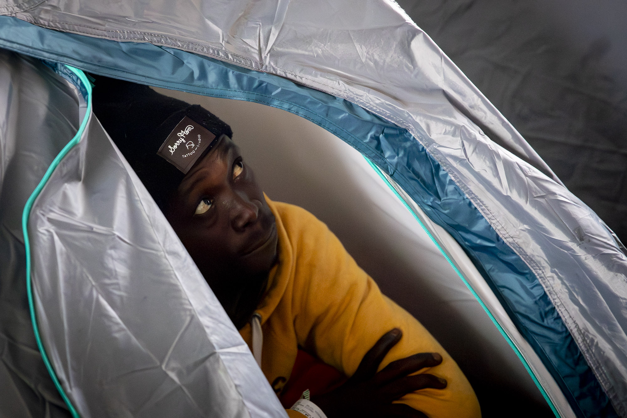 Una de les persones desallotjades a Badalona es refugia del fred i la pluja dins una tenda de campanya. Fotografia: Albert Salamé
