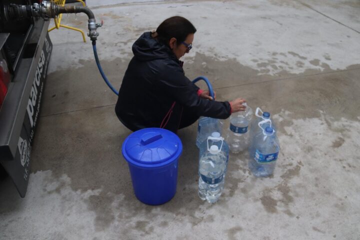 Una dona omple garrafes del camió cisterna a Anglès