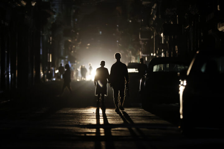 Dues persones caminen per un carrer de l'Havana, la capital de Cuba, durant una apagada el 21 de març. L'embargament nord-americà ha agreujat els problemes crònics de la xarxa elèctrica de l'illa (fotografia: Ernesto Mastrascusa/Efe).