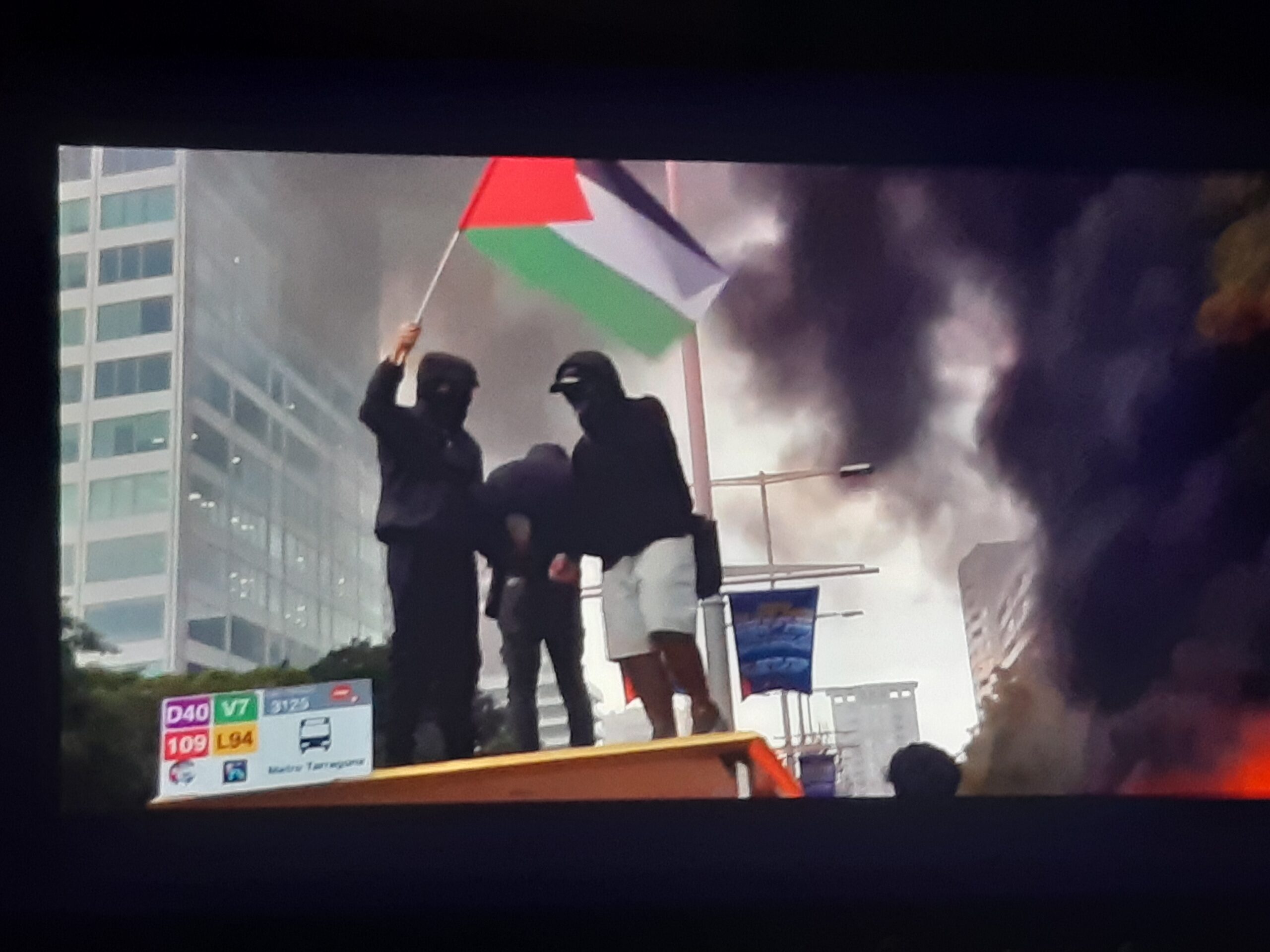 Activistes enfilats en un parada de bus en una protesta per Palestina a Barcelona (X. Montanyà).