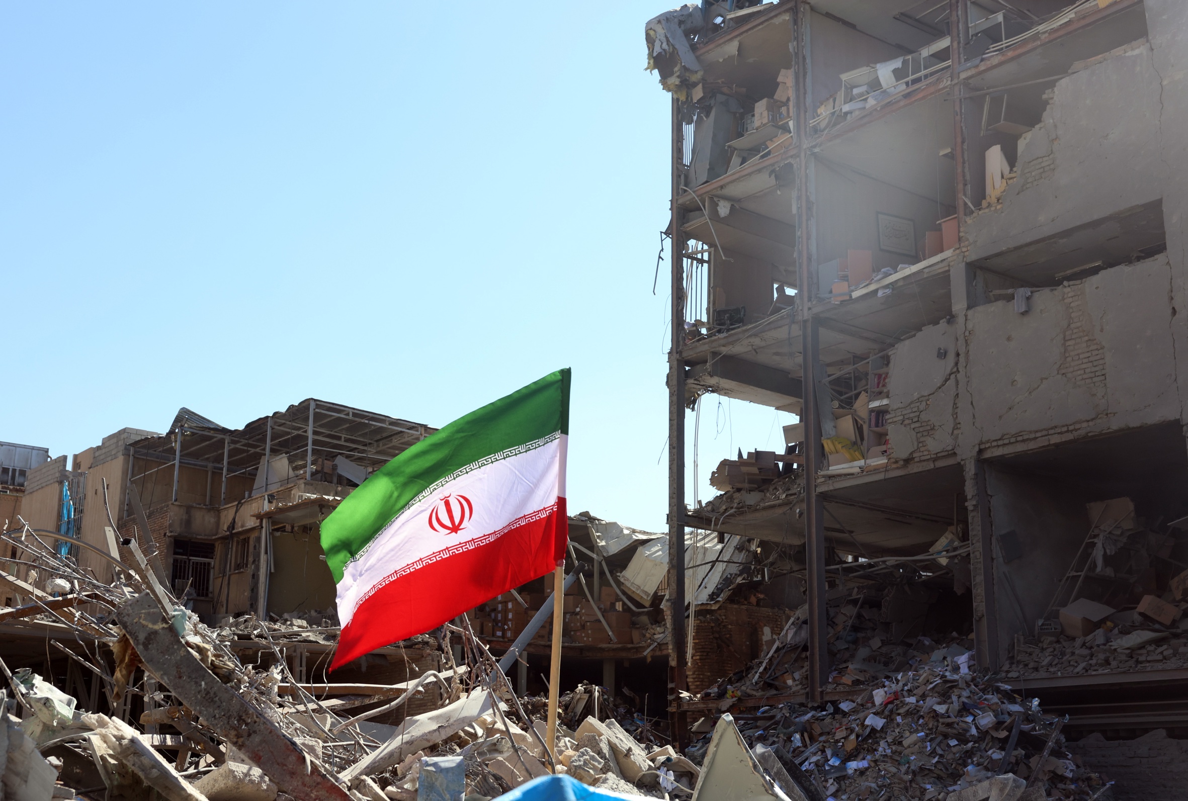 Bandera iraniana sobre les runes d'un edifici destruït per un míssil a la plaça Ferdowsi de Teheran, ahir (fotografia: Abedin Taherkenareh/Efe).